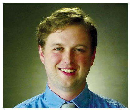 James Barnes in front of a wall of photos. 