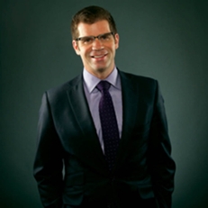 Alumnus Smalley puts his hand on his heart. 