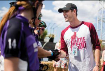 James Barnes in front of a wall of photos. 