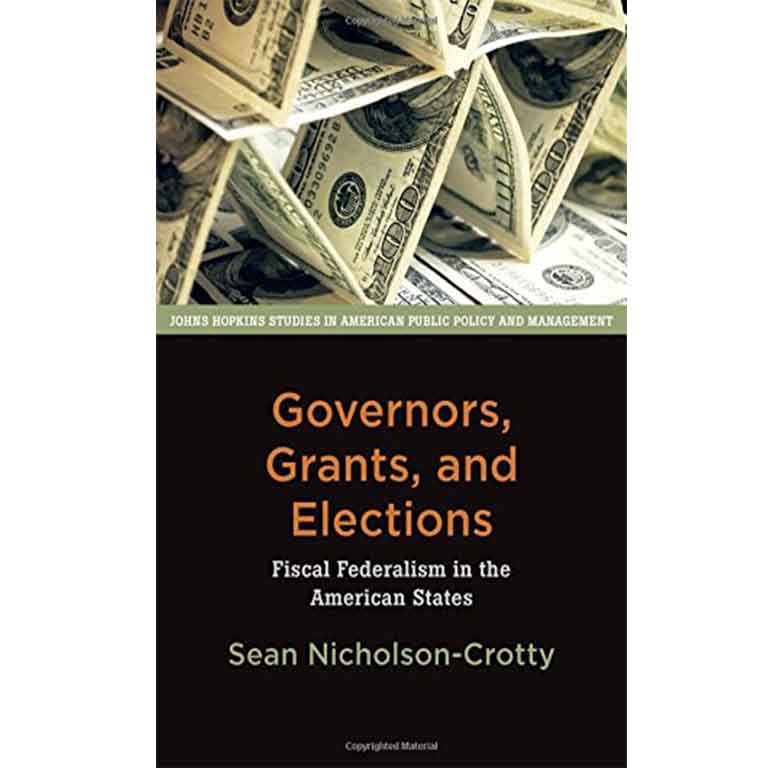 James Barnes in front of a wall of photos. 